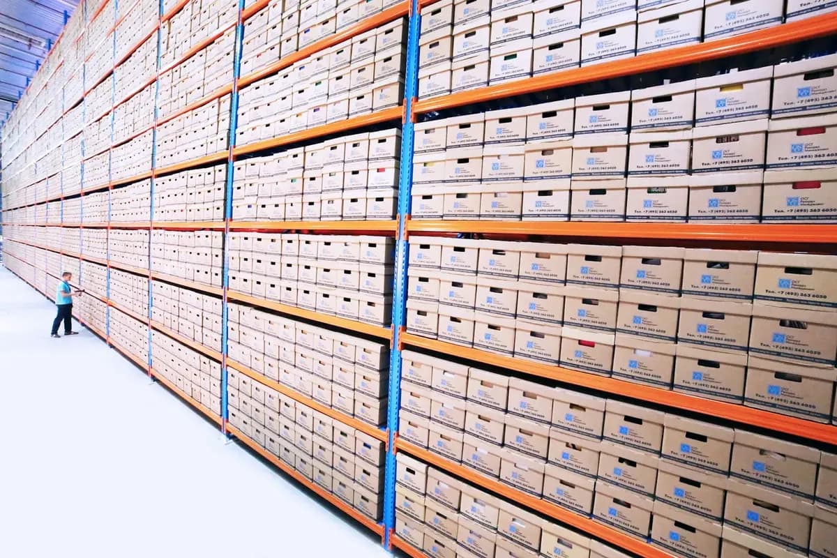 Industrial stores with high racking holding palletised supplies along a long aisle