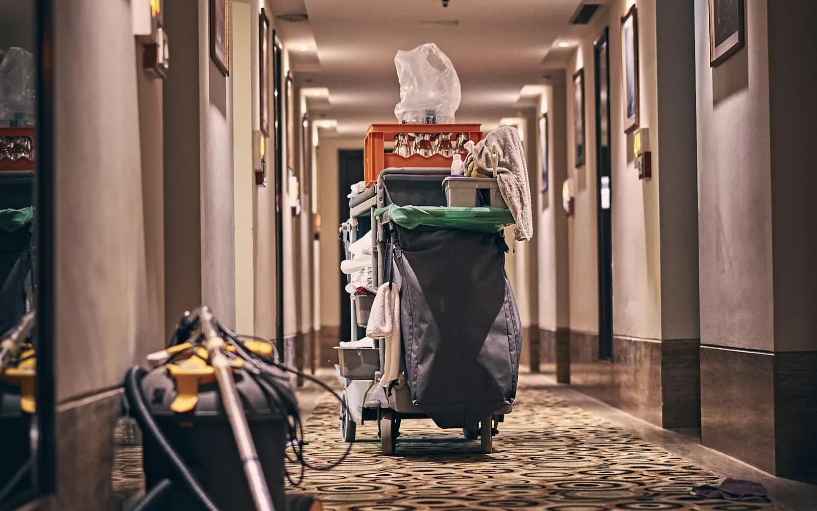 Housekeeping trolley and equipment staged in a hotel guest corridor during a service round